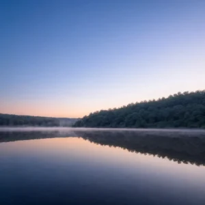 Sunrise over Big Lake, capturing the tranquil waters and surrounding forest - Parksguidance Official